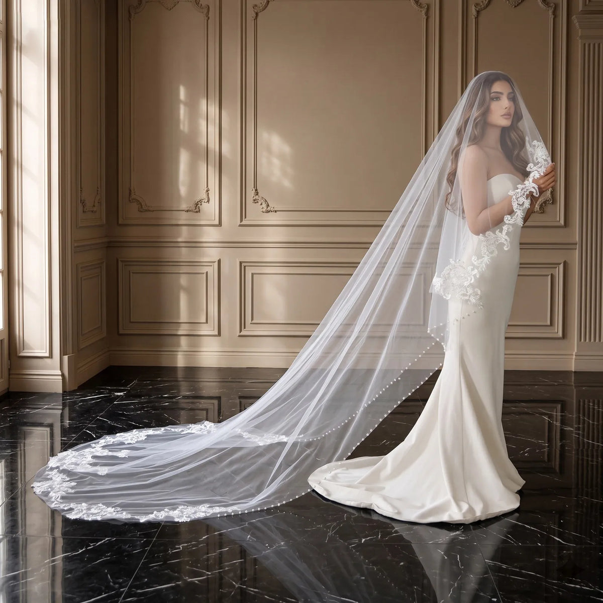 Profile view of bride standing in luxurious interior with sweeping 300cm lace trimmed veil