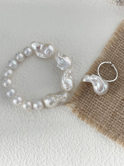 Large baroque pearl elastic bracelet paired with a matching baroque pearl open ring on fabric.
