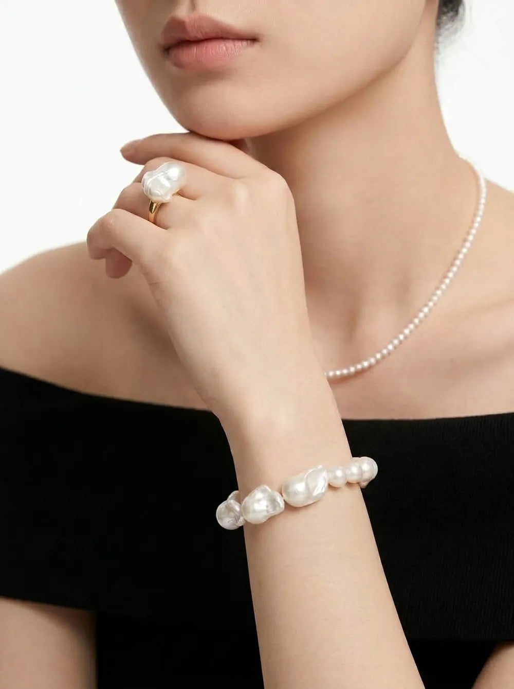 Model wearing the large baroque pearl elastic bracelet on wrist paired with a baroque pearl ring.