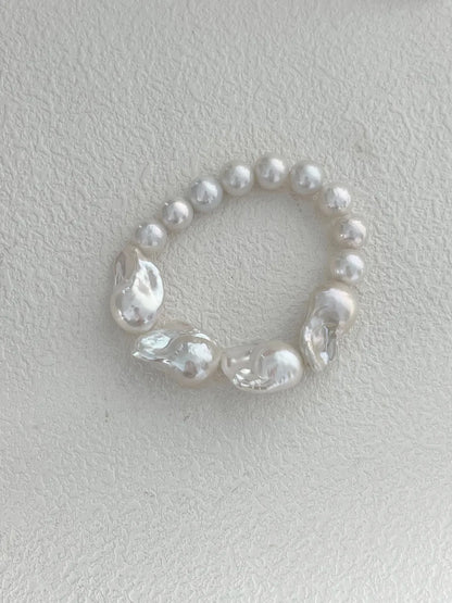 Overhead view highlighting the raw organic textures and round pearl splicing of the bracelet.