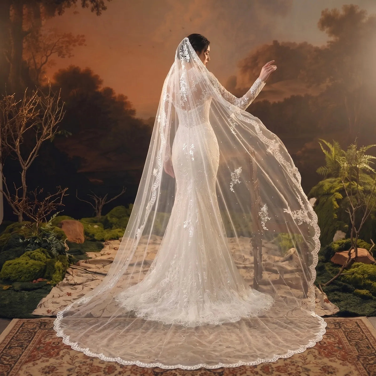 Side back view of bride wearing a floor length lace cap mantilla veil with leaf vine appliqués