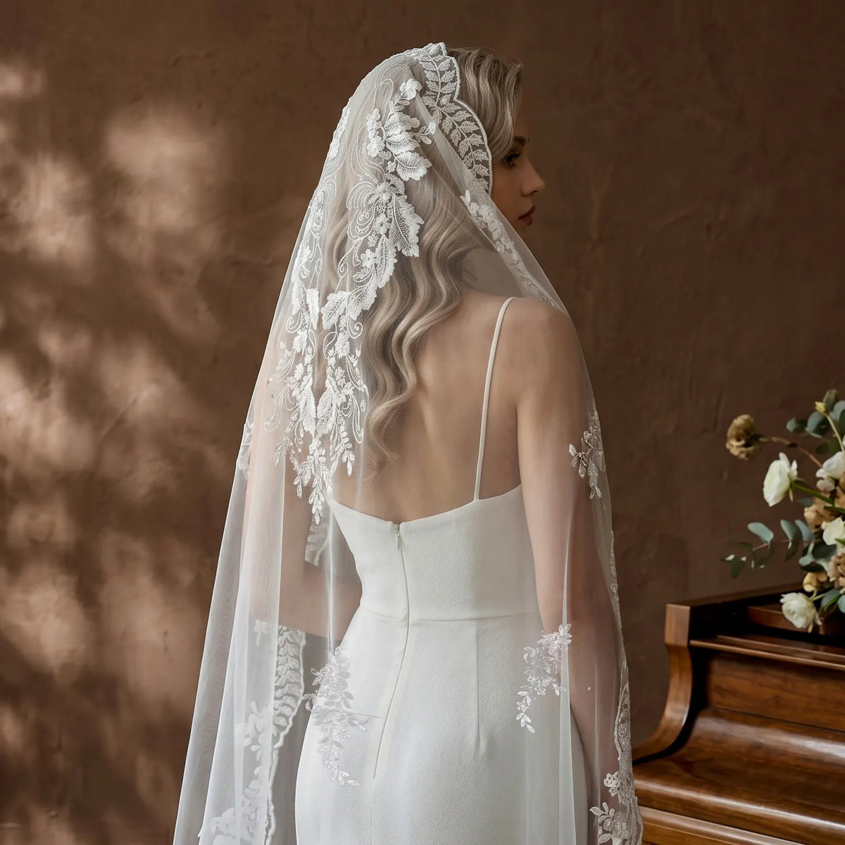 Detailed back view of leaf crown mantilla veil headpiece showing delicate lace cascading down blonde hair