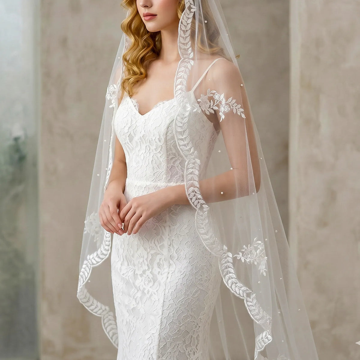 Portrait of model displaying leaf vine lace trim veil framing the shoulders with soft pearl scatter