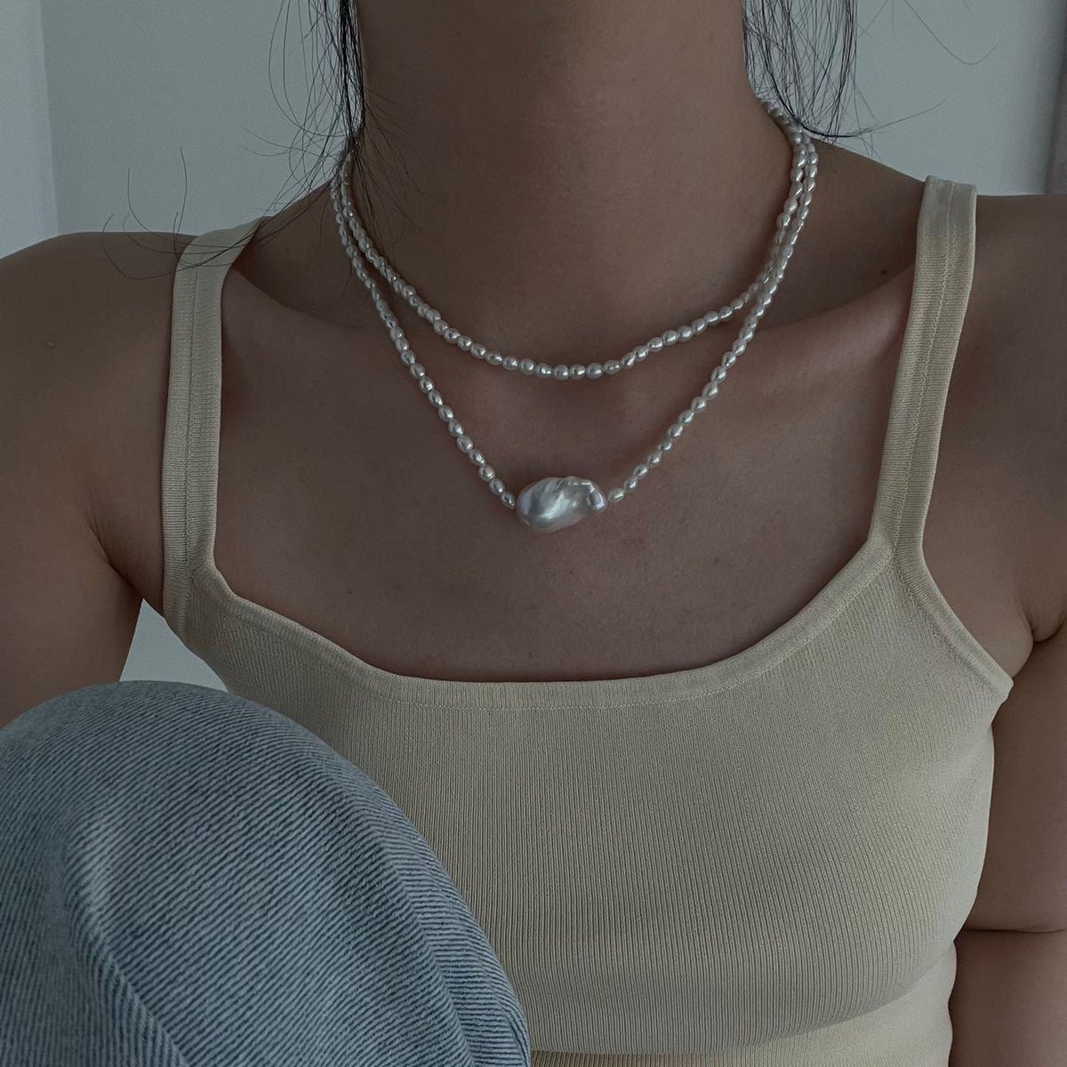 Long freshwater pearl necklace worn in a layered style around the neckline