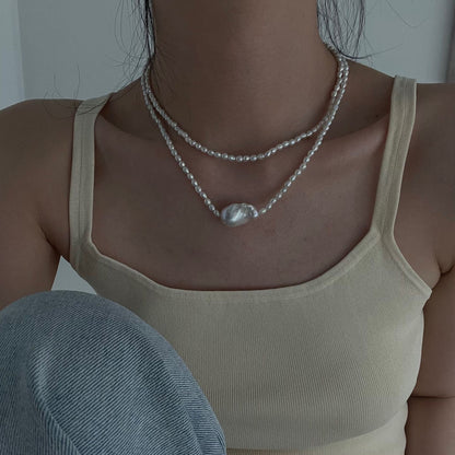 Long freshwater pearl necklace worn in a layered style around the neckline