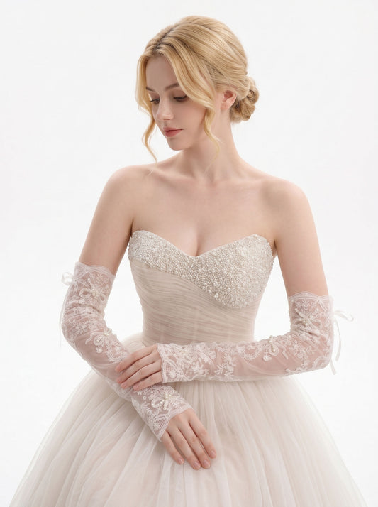 Elbow‑length finger‑less lace bridal gloves with floral embroidery bow appliqué worn with wedding dress