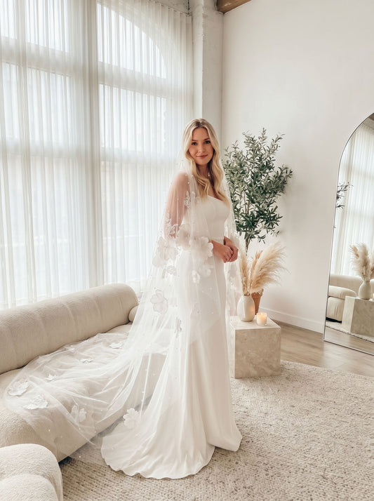 Long cathedral wedding veil with floral lace details flowing behind a bride