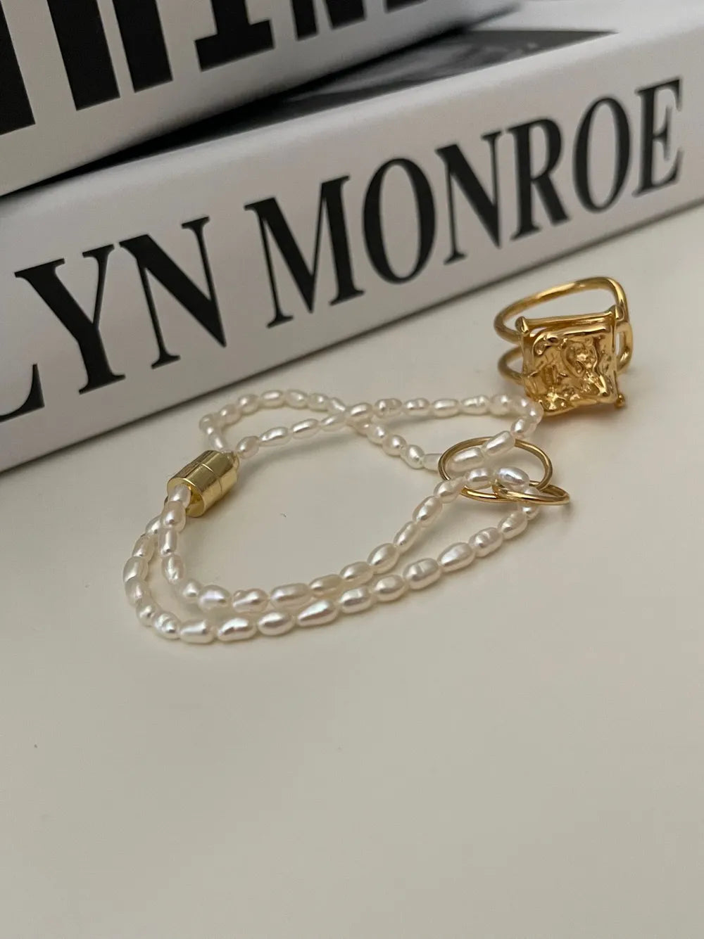 Close-up view of the gold magnetic closure and lustrous freshwater seed pearls.