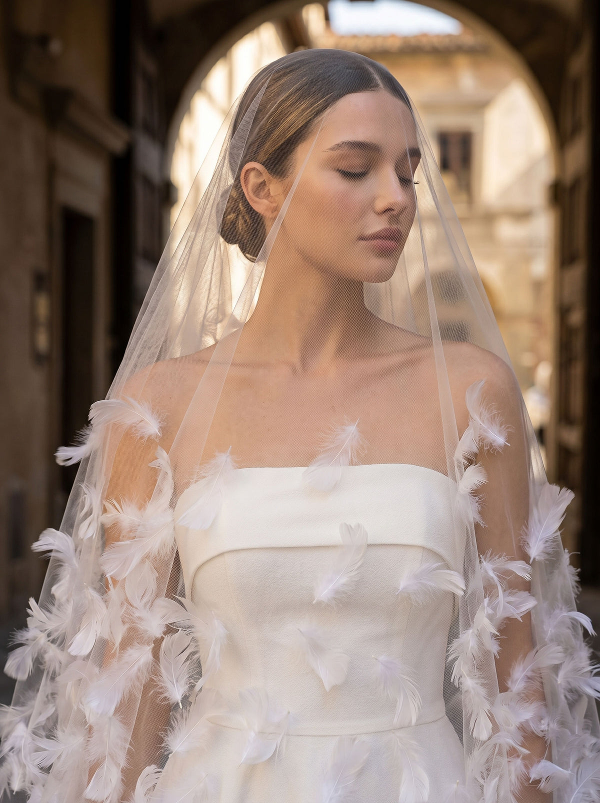 White feather embellished mid-length sheer tulle bridal veil