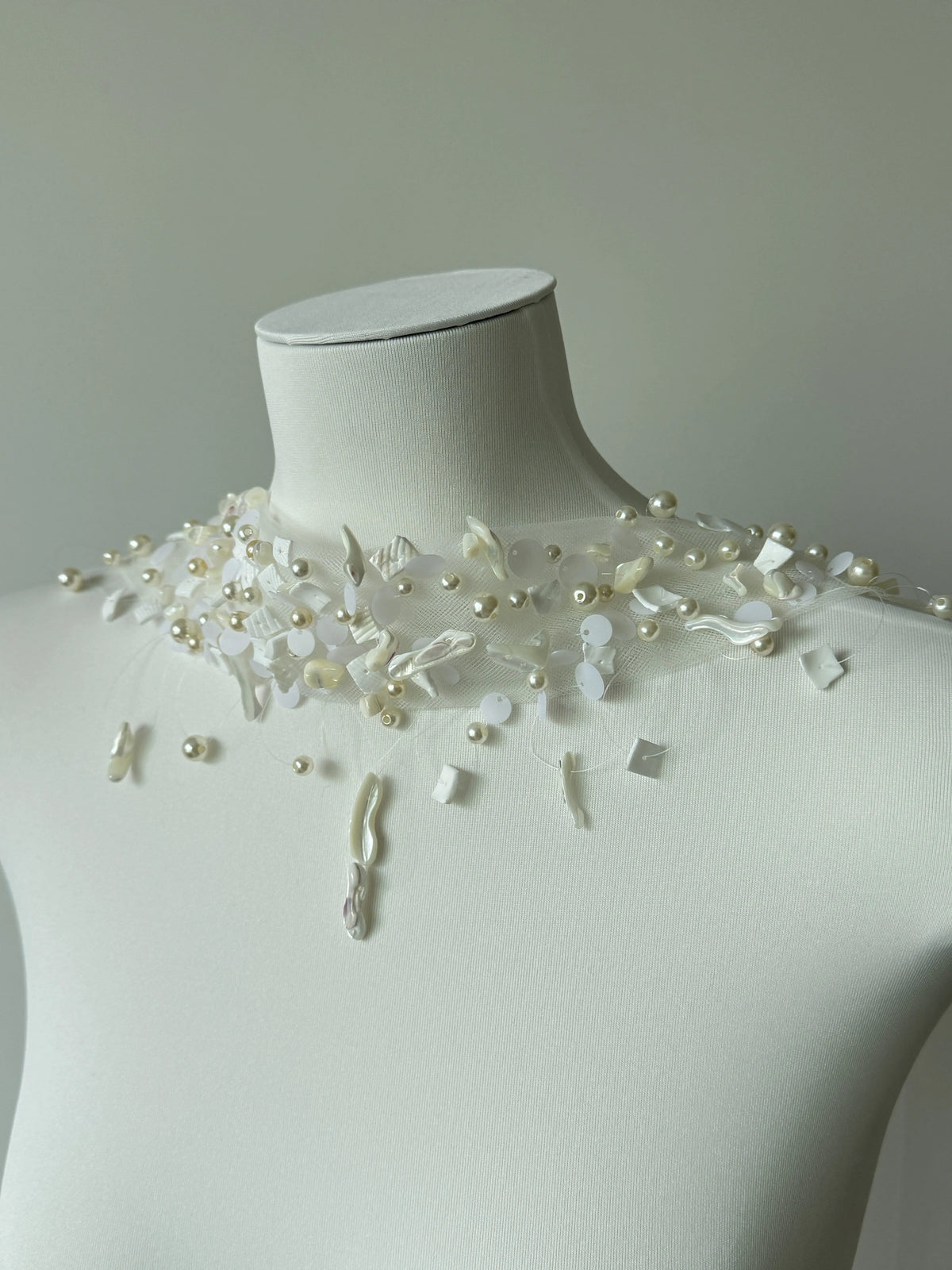 Modern coastal mermaid style halter bridal cape veil featuring exquisite natural seashell embellishments, iridescent mother-of-pearl flakes, and clear glass bead embroidery around the neckline.