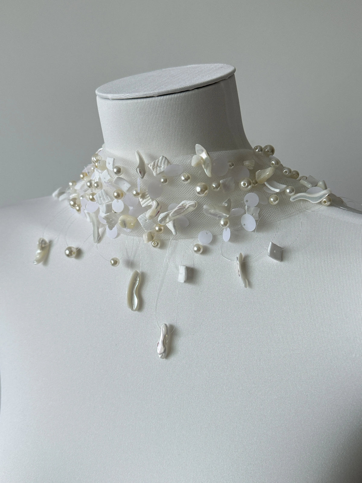 Modern coastal mermaid style halter bridal cape veil featuring exquisite natural seashell embellishments, iridescent mother-of-pearl flakes, and clear glass bead embroidery around the neckline.