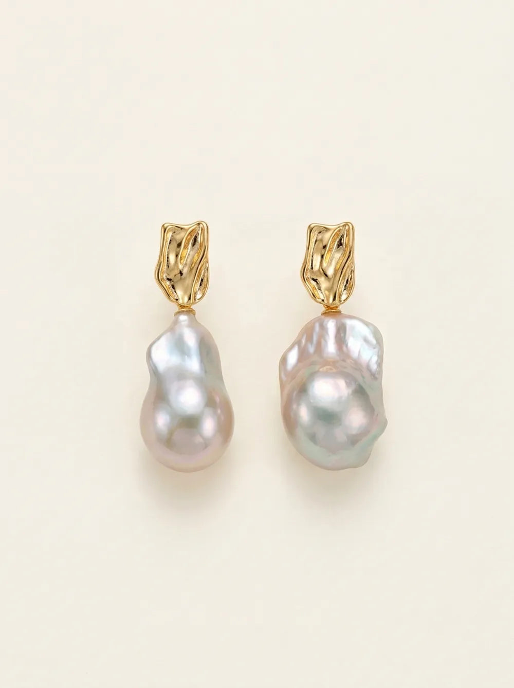 Front flatlay pair view of molten metal liquid texture large baroque pearl drop earrings.