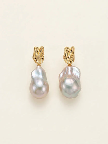 Front flatlay pair view of molten metal liquid texture large baroque pearl drop earrings.