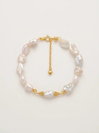 Flatlay view of the circular moustache baroque pearl bracelet with gold S925 silver caps.