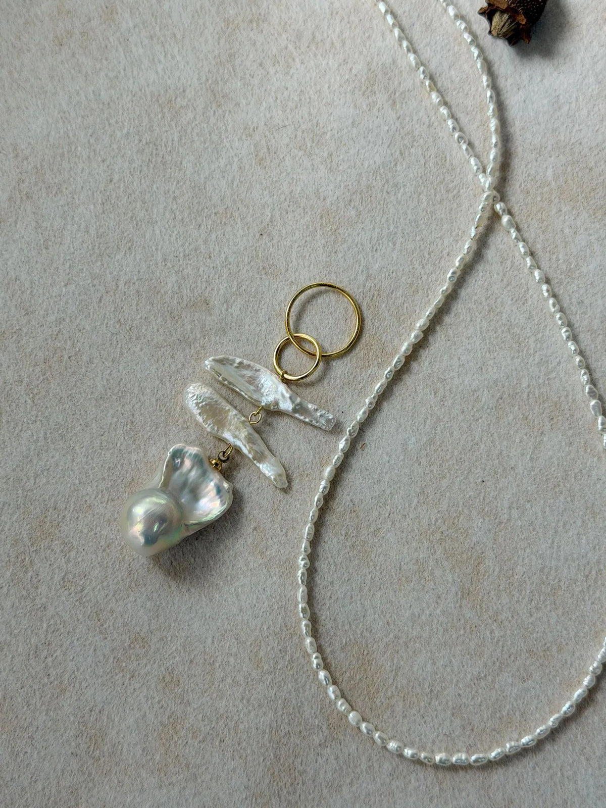 Close-up shot showing the radiant luster and natural texture of the large baroque pearl pendant.