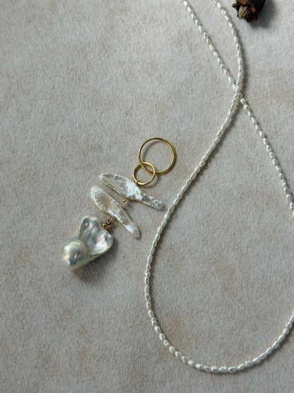 Close-up shot showing the radiant luster and natural texture of the large baroque pearl pendant.