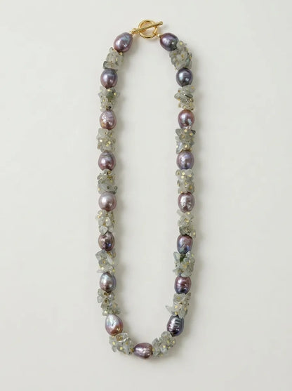 Straightened flatlay view of moonstone chip and purple baroque pearl necklace with OT clasp.