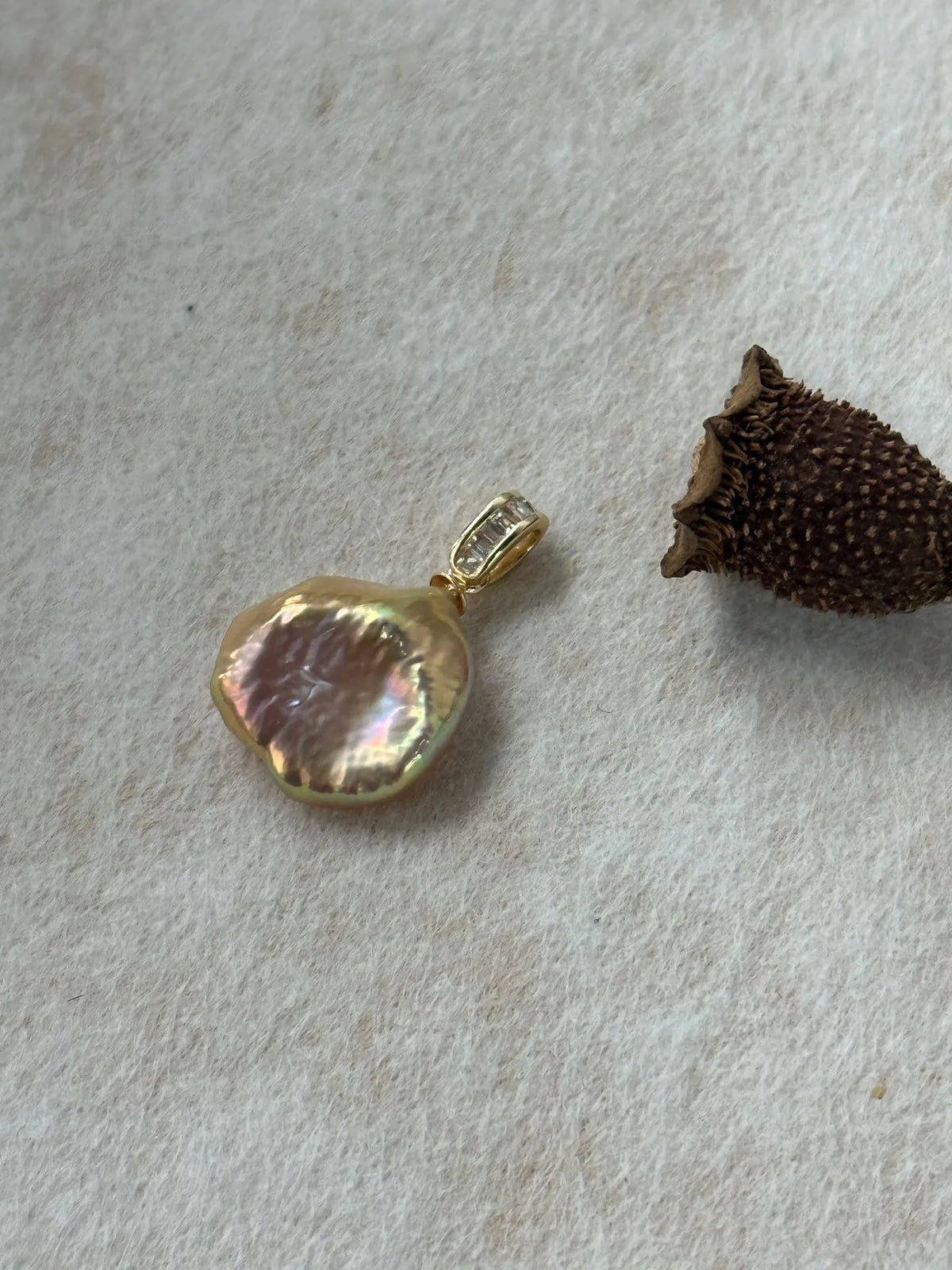 Close-up detail of the iridescent natural freshwater petal pearl pendant.