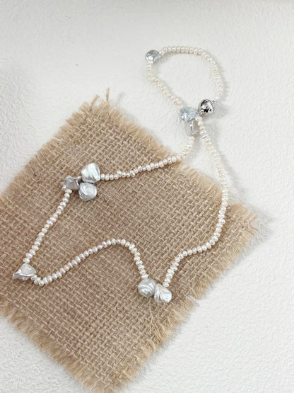 Asymmetrical organic petal freshwater pearl choker on a natural burlap background