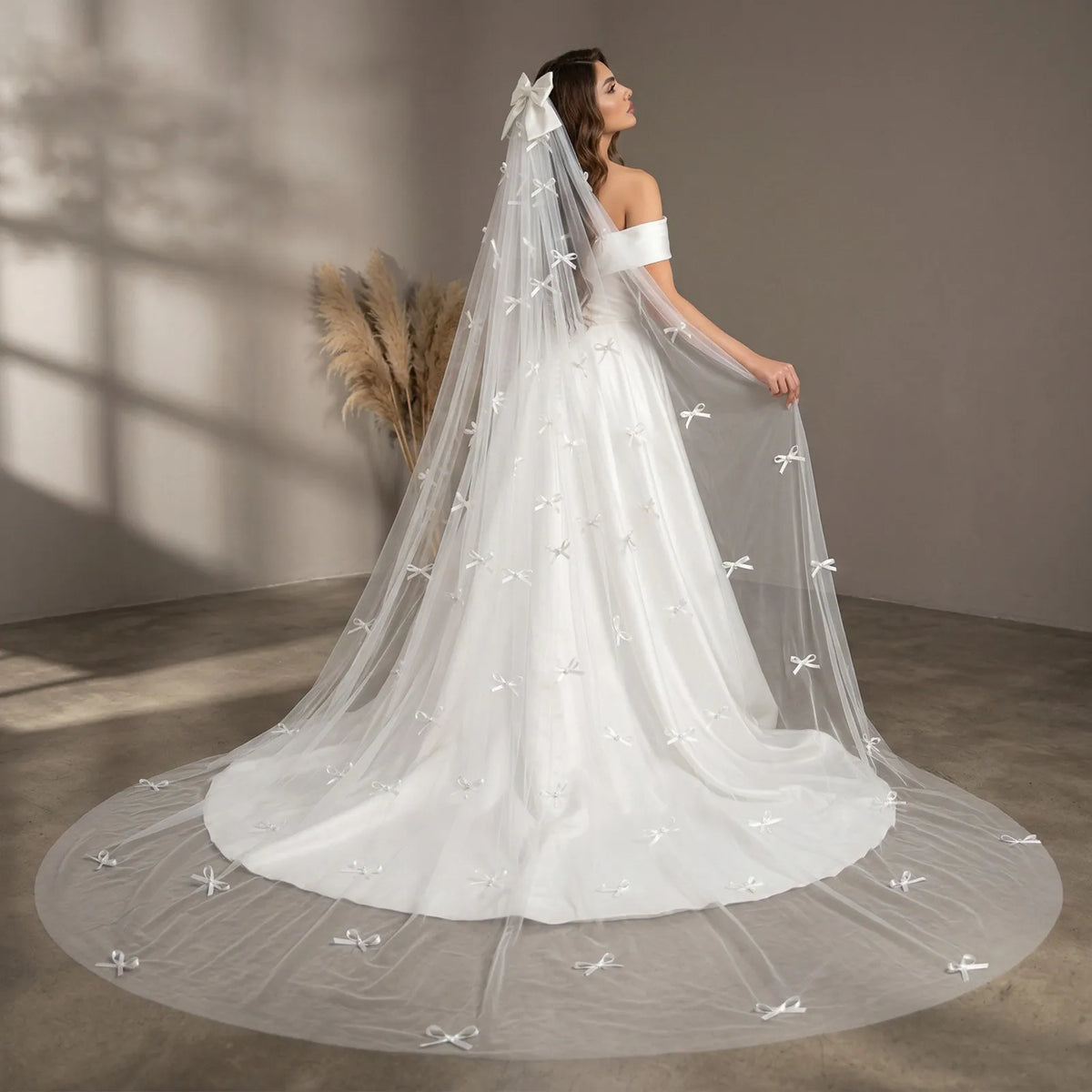 Back view of studio mannequin showing full 300cm spread of sheer veil scattered with ribbon bows
