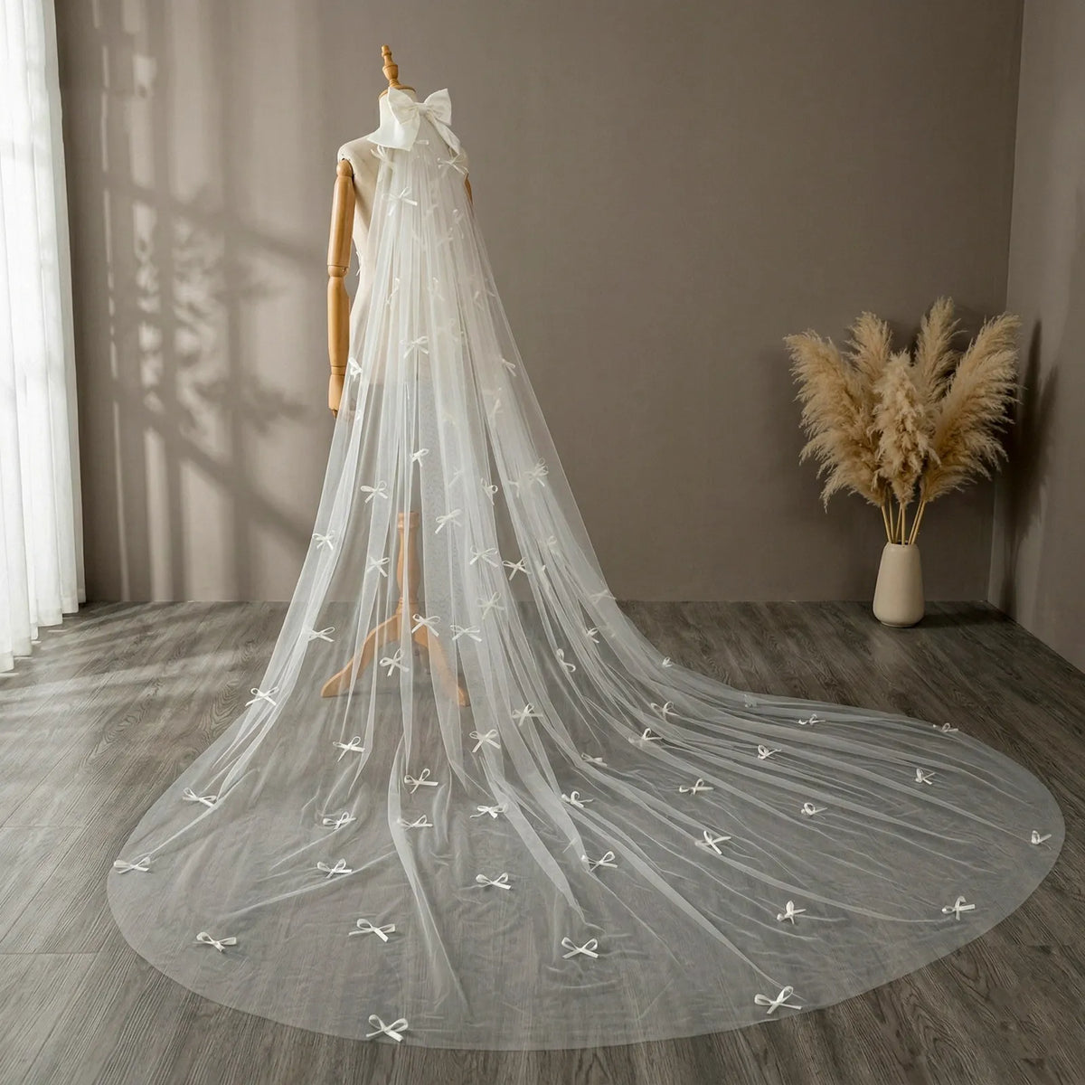 Close-up of black studio mannequin displaying top satin bow attachment and scattered mini bow details