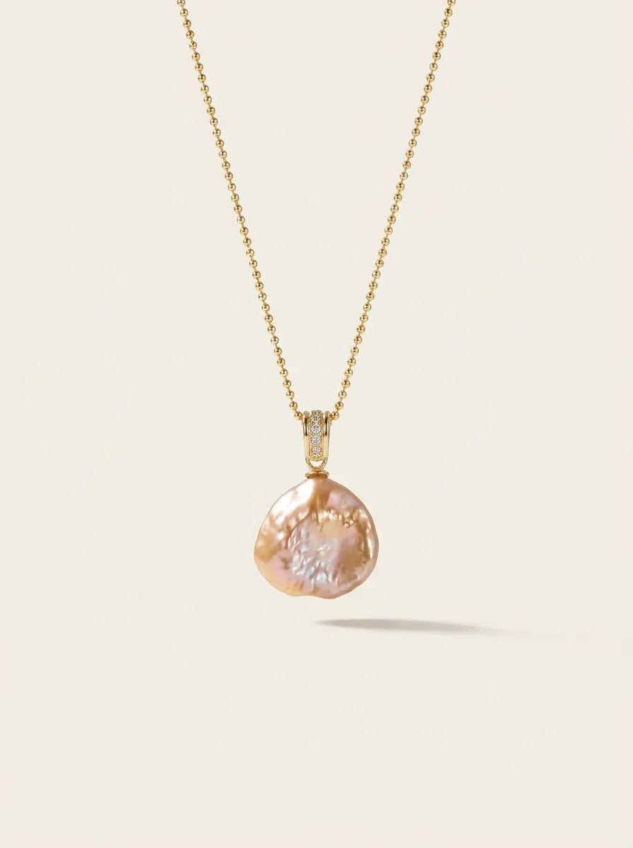 Studio shot of the petal baroque pearl pendant with pavé bail on a gold beaded chain.