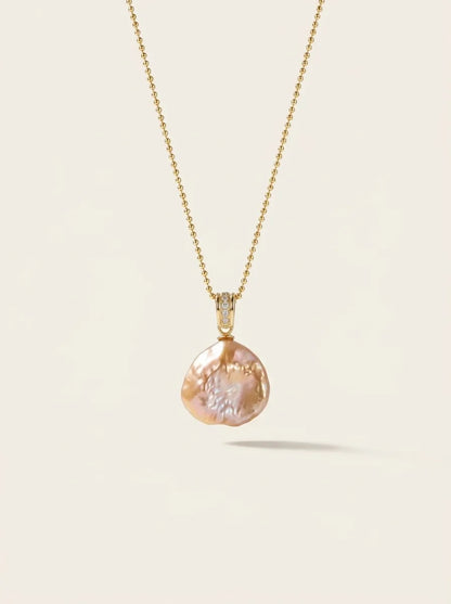 Studio shot of the petal baroque pearl pendant with pavé bail on a gold beaded chain.