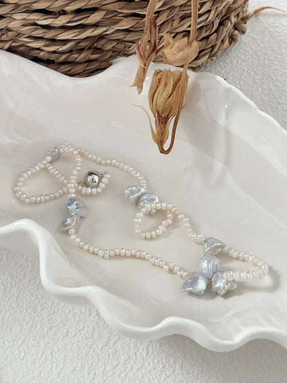 Bridal petal freshwater pearl choker elegantly styled in a white ceramic shell dish
