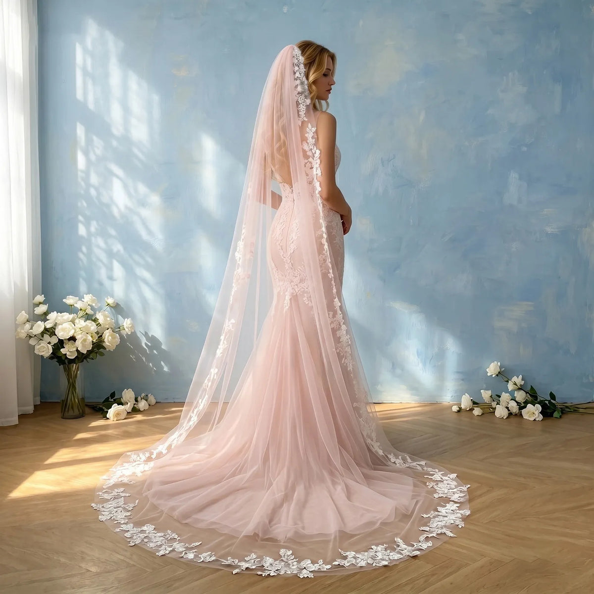 Back view of bride wearing mermaid gown with trailing soft pink floral lace cathedral veil