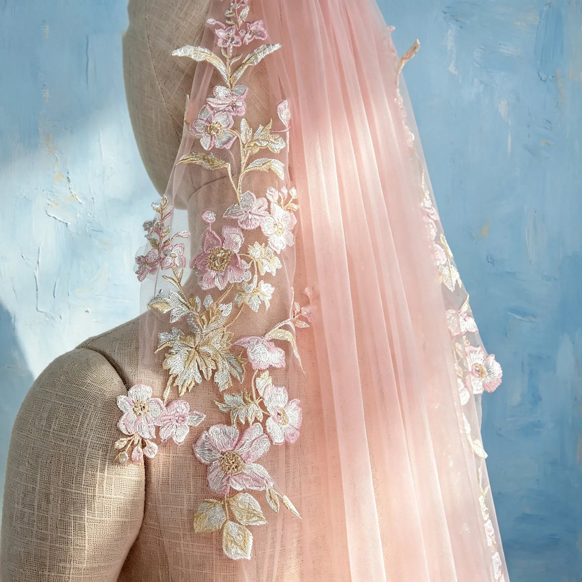 Side view on dress form mannequin displaying blush pink embroidered floral lace appliqué on tulle