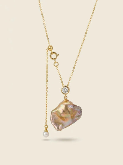 Flatlay view of giant rainbow freshwater baroque pearl pendant with adjustable tail pearl.