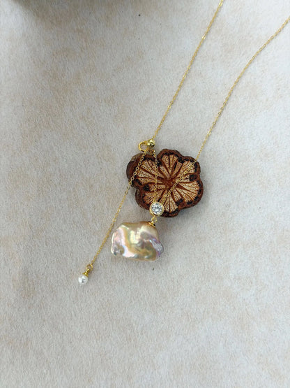 Natural rainbow baroque pearl long necklace displayed on a wooden flower prop showcasing CZ charm.
