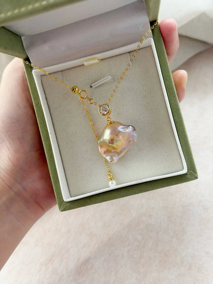 Rainbow galaxy baroque pearl long necklace presented inside a green velvet jewelry gift box.
