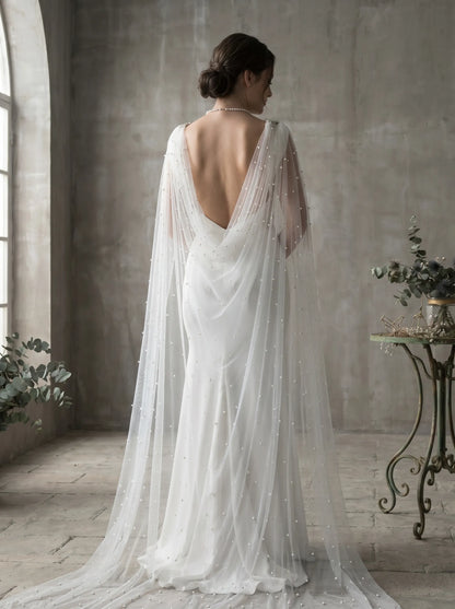 Wide cathedral bridal cape flowing behind wedding dress