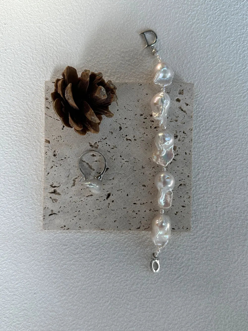 Extended rice and large baroque pearl bracelet displayed with a matching baroque pearl silver ring.