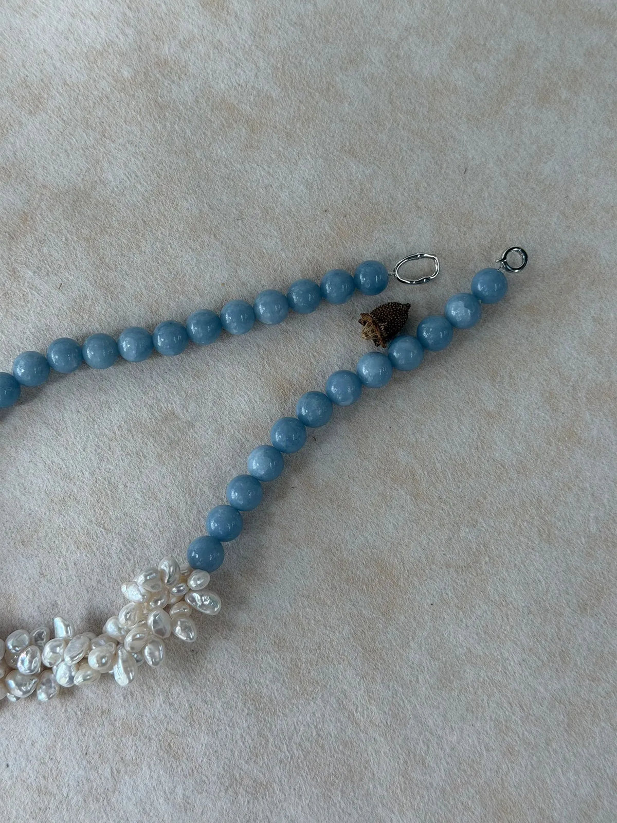 Close-up shot of the S925 sterling silver clasp and connector loop on the blue angelite bead chain.