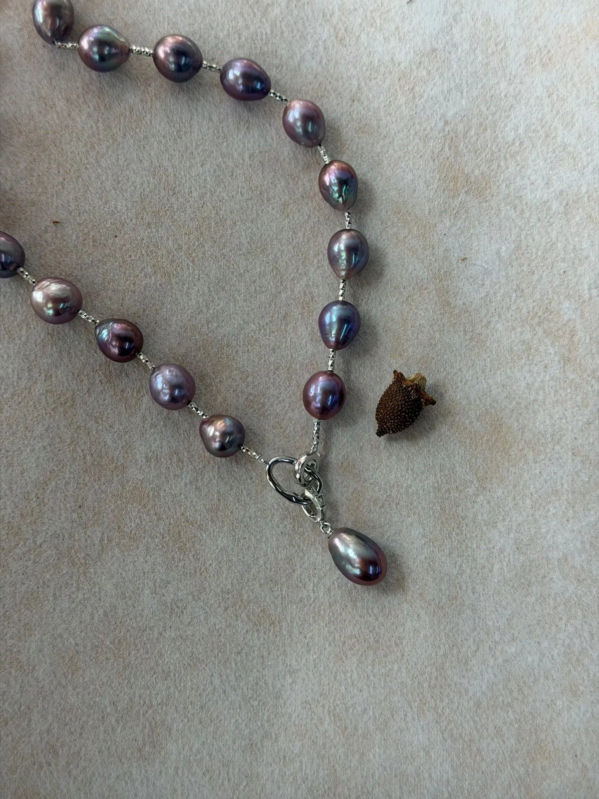 Close-up view of S925 sterling silver front clasp with detachable teardrop baroque pearl pendant.