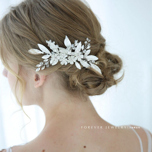 Side view of bride hairstyle decorated with silver floral leaf crystal hair comb, romantic updo wedding hair decoration