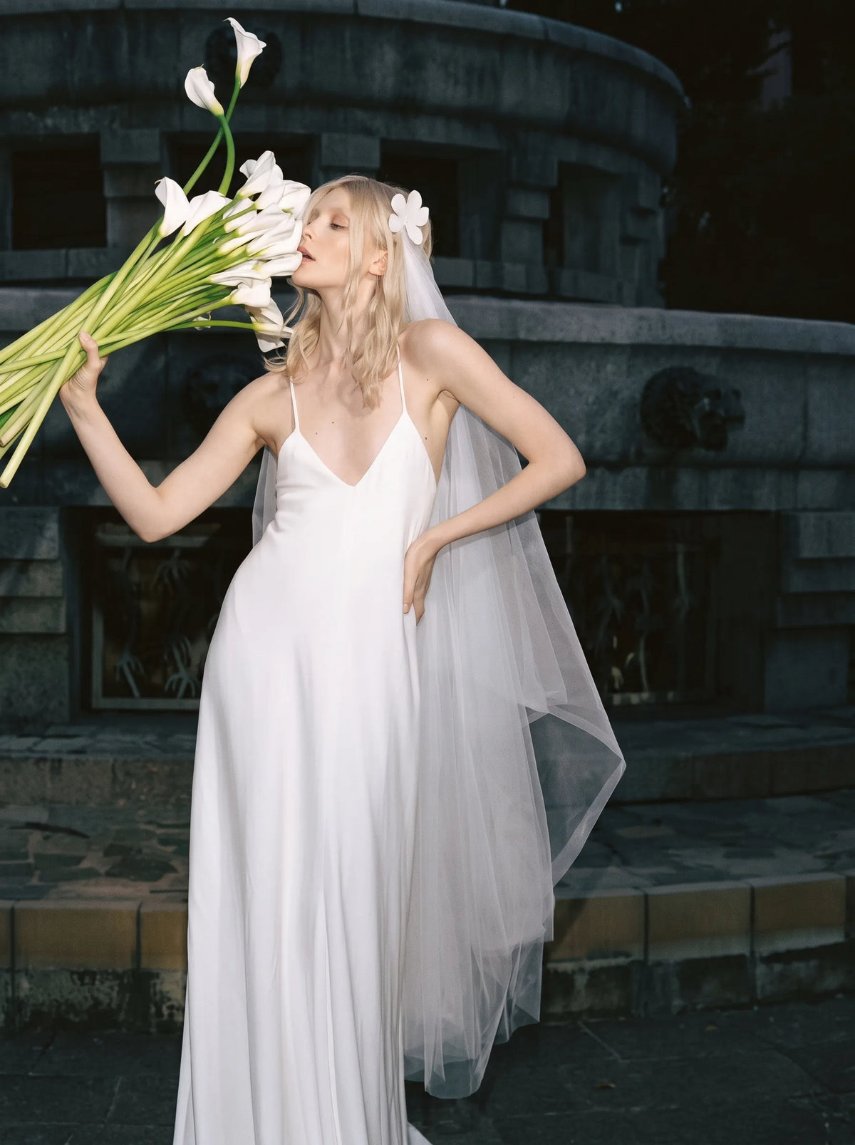 Modern minimalist single-tier cathedral length bridal veil made of high-density soft tulle, attached with handcrafted 3D white satin flower alligator clips.