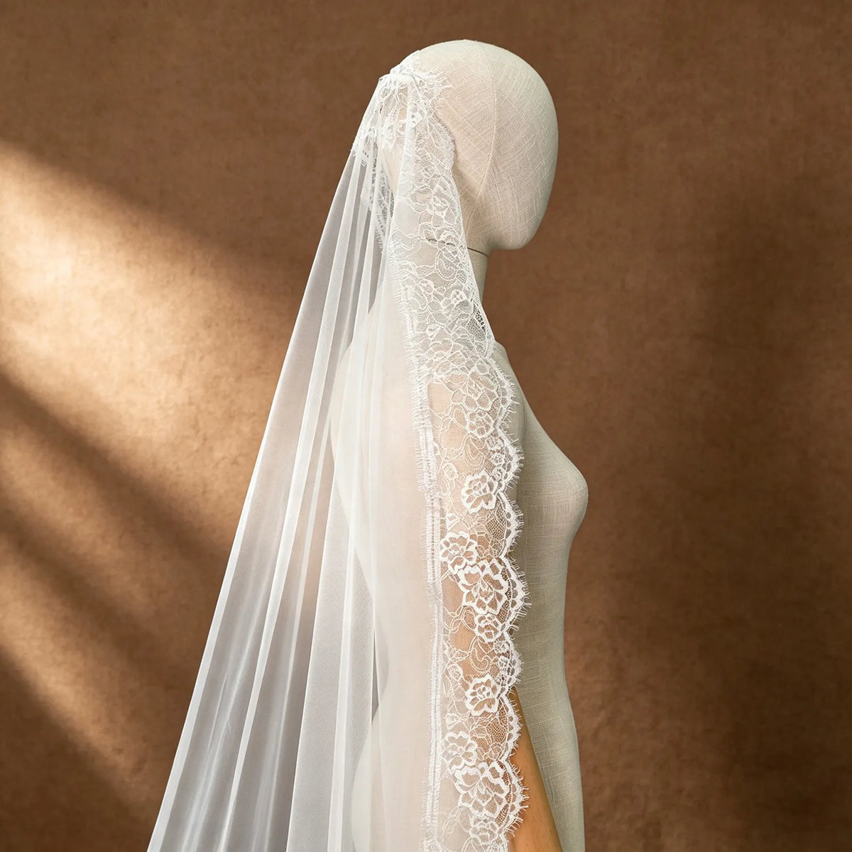 High-angle close-up demonstrating the sheer transparency and soft, airy texture of the high-grade white bridal tulle fabric