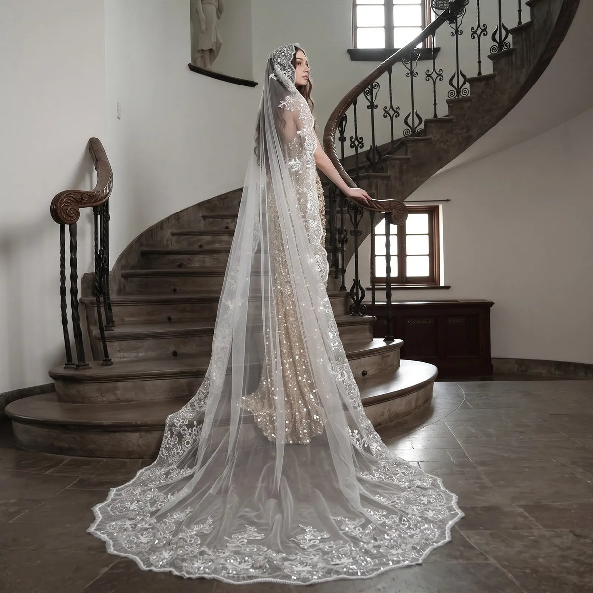 Bride on grand indoor staircase displaying wide 300cm single-tier cathedral veil train with fully spread sequin lace edge