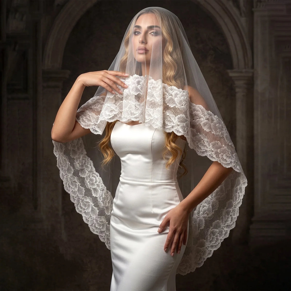Glamour shot of bride wearing blusher veil with scalloped wide floral lace edge in historic archway setting
