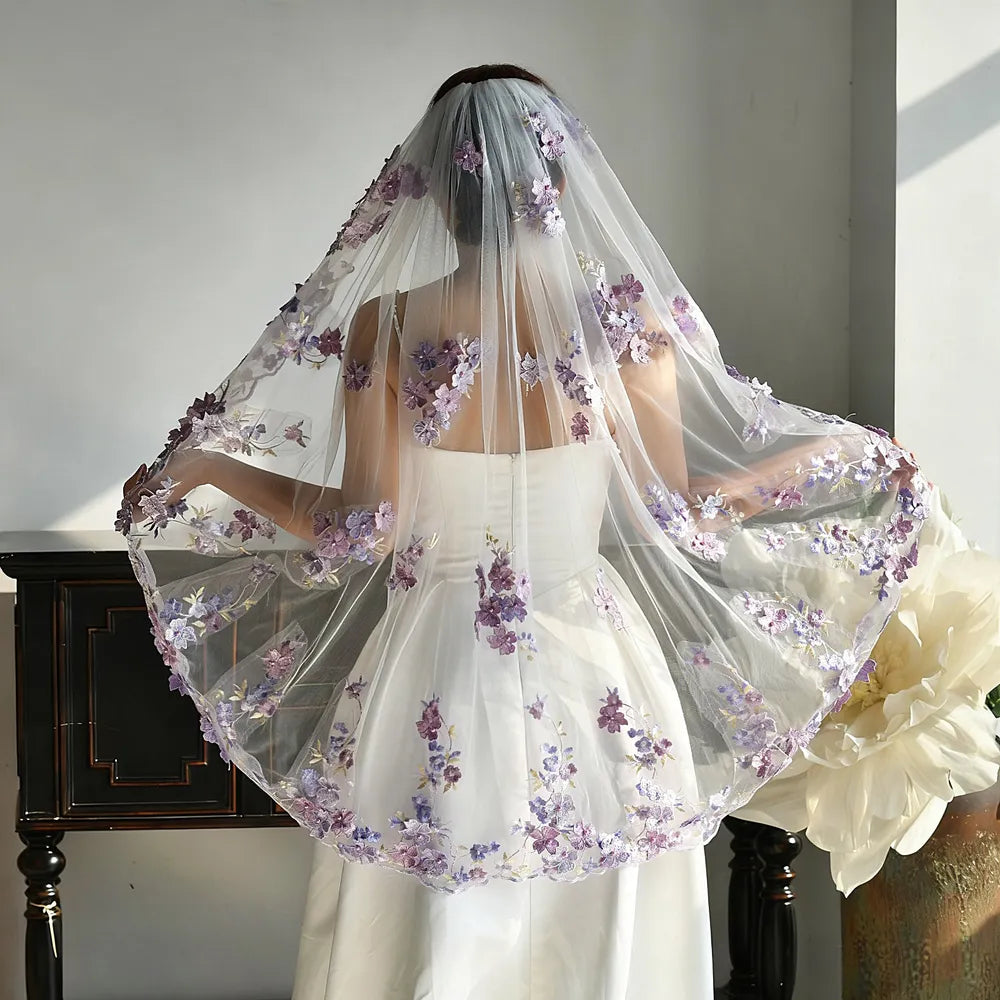 Rear view of bride gently holding out the sides of the 100cm fingertip purple floral lace veil, demonstrating full 160cm width coverage over the wedding gown