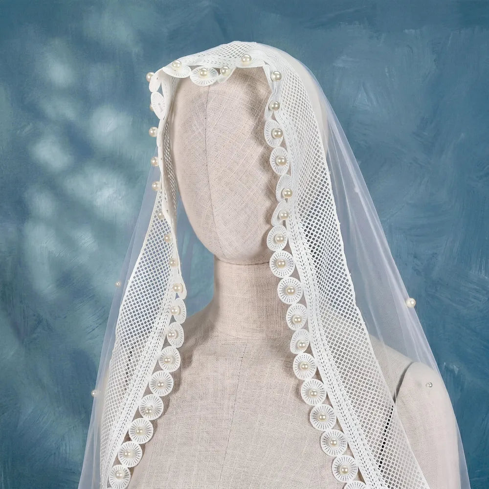 High contrast close-up shot highlighting the structured crochet mesh border and hand-set pearl craftsmanship