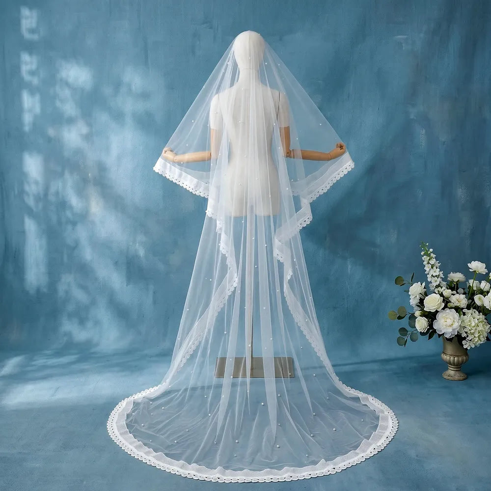 Rear portrait of bride walking with 300cm single-tier pearl veil trailing smoothly across marble flooring