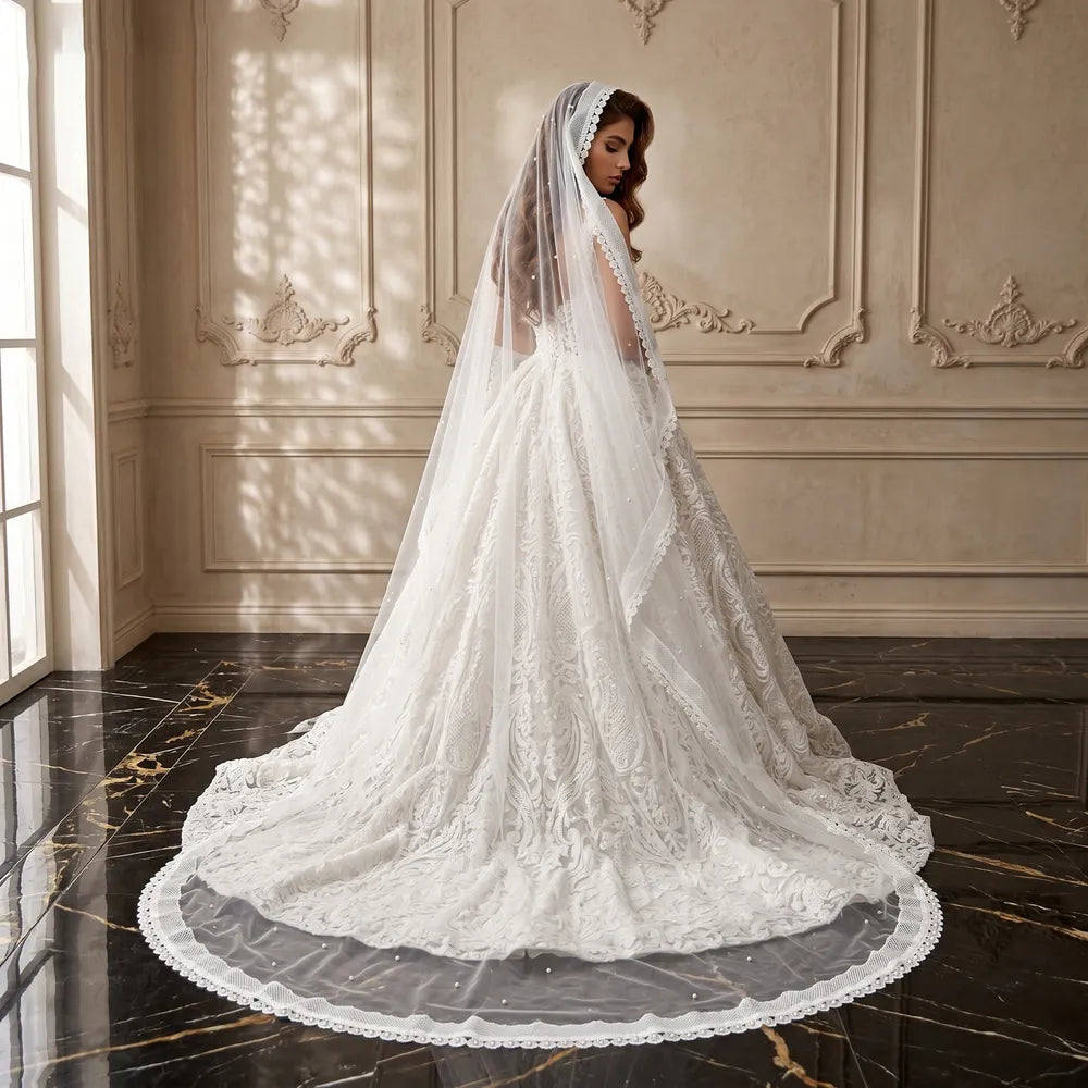 Rear portrait of bride walking with 300cm single-tier pearl veil trailing smoothly across marble flooring