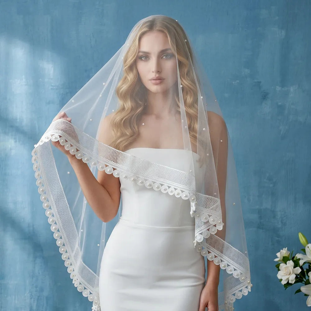 Sunlight shining through sheer soft single-tier tulle and scattered pearls, creating a glowing ethereal bridal aesthetic