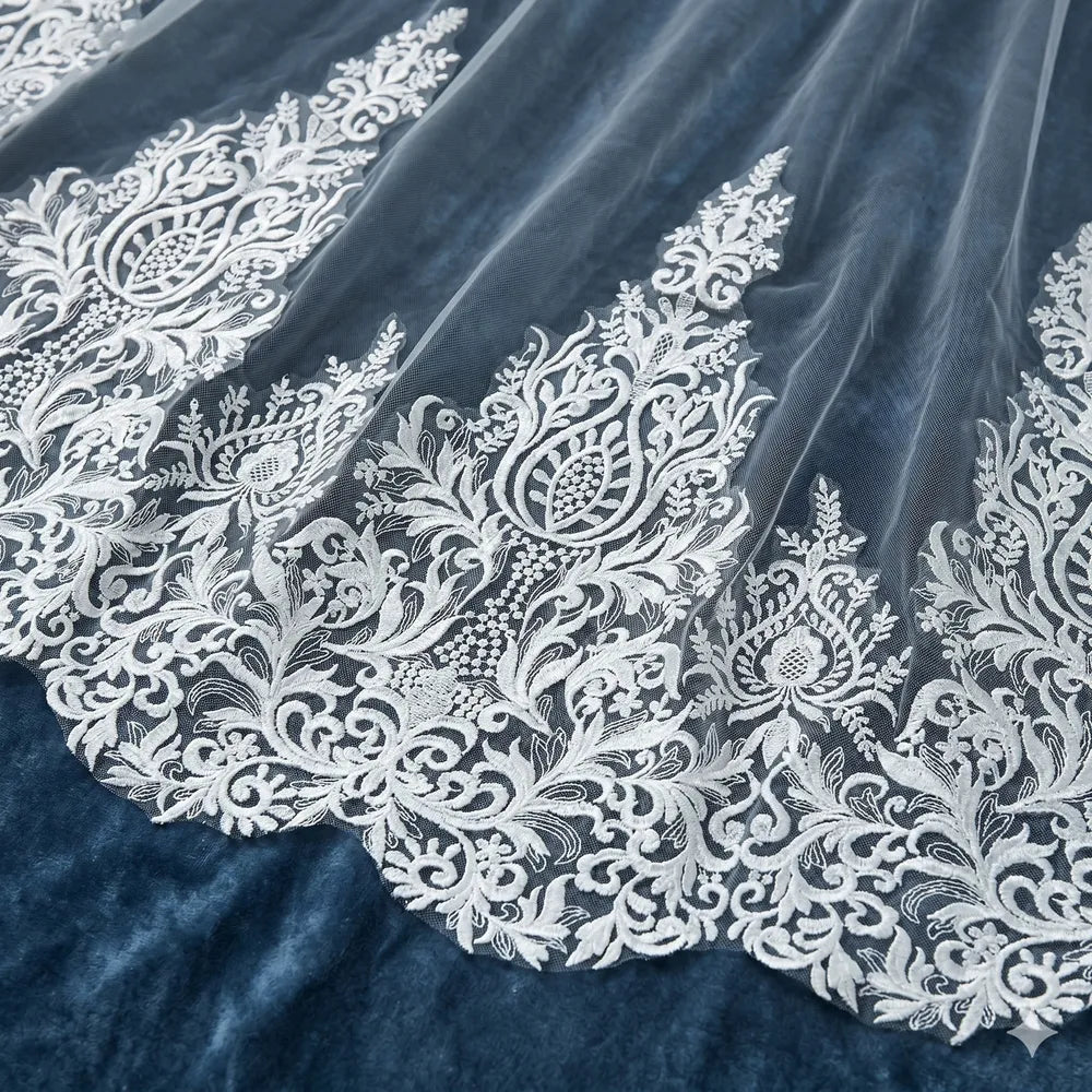 Macro close-up shot showing delicate Baroque floral embroidered lace appliques along scalloped veil hem