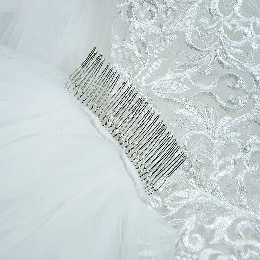Close-up view of sturdy metal comb securely hand-stitched into soft white tulle mesh for secure bridal hold