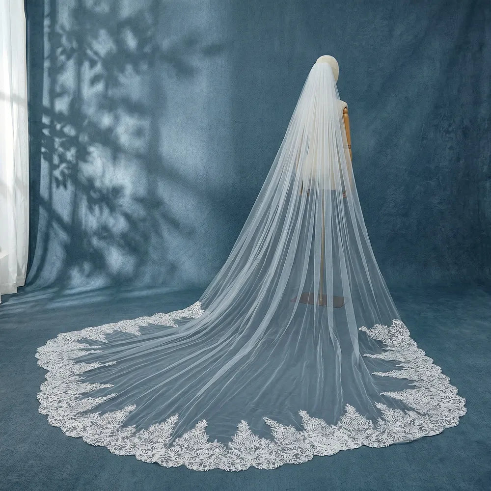 Side profile portrait of bride showing cathedral veil attachment near low chignon hairstyle with cascading tulle